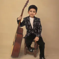 A young musician in the making. This portrait of a boy with his guitar has a cool, relaxed vibe, capturing a personal interest in a stylish way.