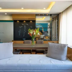 A pop of color from fresh yellow flowers brings warmth and personality to this cozy bedroom, where a mix of textures and tones creates a welcoming and stylish atmosphere.