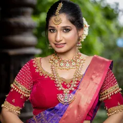 This vibrant red and royal purple silk saree is a bold and beautiful choice for a bride. The intricate beadwork on the blouse adds a touch of modern craftsmanship to the traditional pattu saree.