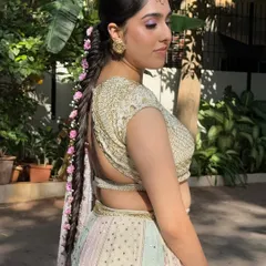A side profile showing how the lilac eyeshadow and the floral braid come together for a cohesive and dreamy Haldi look.