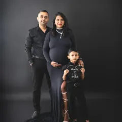 We love adding a touch of drama to our family maternity sessions. This portrait uses a classic black backdrop and matching outfits to create a powerful, stylish image, celebrating the son's promotion to 'big brother'.