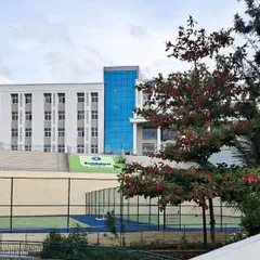 A view of the EuroSchool campus showing the main building in context with the outdoor sports court. This highlights our planning for integrated indoor and outdoor student activities.