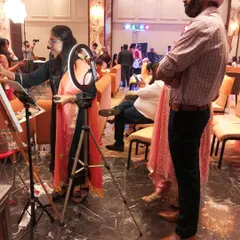 Guests often gather to watch the painting progress. Here, at a 50th-anniversary party in Faridabad, guests look on as I add details to the couple's portrait.