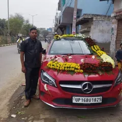 I also decorate luxury cars like this red Mercedes. The decoration uses a combination of yellow marigolds and red roses to complement the car's color.