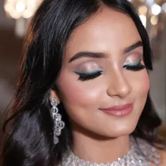 A detailed close-up of the emerald magic eye makeup. The shimmery lids and crisp green winged liner create a statement that is both soft and striking, perfect for a modern bride.