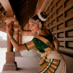 A side profile of a dancer, capturing the elegance of her pose and the intricate details of her hairstyle and costume. The soft light adds a gentle, timeless quality.