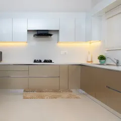 The full view of this kitchen showcases the integrated refrigerator and the balance between the upper white cabinets and the lower beige ones. It’s a harmonious and functional space.