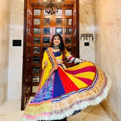 The energy of Garba and Navratri calls for something truly special. This vibrant, multi-paneled lehenga is full of life, featuring a kaleidoscope of colors, traditional patterns, and a playful fringe border, designed to make every twirl unforgettable.
