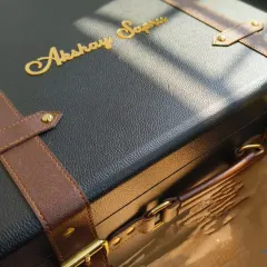 This close-up shows the detail on a personalized leatherette trunk, part of a large order for a 20-year partnership celebration between Axis Bank and Yes Bank. Each trunk was customized with the recipient's name in gold, making it a truly memorable milestone gift.