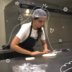A participant carefully rolls out dough on a professional steel countertop. In our workshops, you learn the proper techniques for handling and shaping different types of bread.