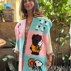 Here is my mom, Nirmala, proudly showing off a one-of-a-kind tapestry muffler we made for a customer. It features fun cartoon characters like Snoopy, sheep, and ducks, all hand-stitched with love. We can create a custom story just for you.