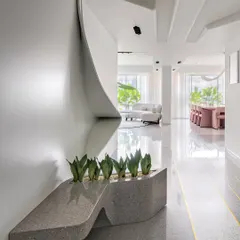 This dining area in the House of Basho features a custom-designed table and built-in seating, creating an intimate yet open space. The use of natural wood and earthy tones enhances the home's connection to its surroundings.