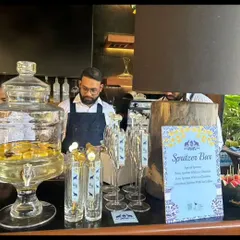 A dedicated Spritzer Bar set up for an intimate gathering. We provide large glass dispensers of pre-mixed spritzers and a variety of fresh fruit garnishes for guests to customize their drinks.