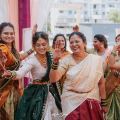 The bride dances with her family, their hands decorated with henna and haldi. These are the unscripted, happy moments that truly define the celebration.