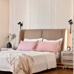 A bedroom should be a retreat. Here, we used a soft, muted color palette, layered textures with a custom upholstered headboard, and added fluted paneling to create a serene space that feels like a gentle embrace at the end of the day.