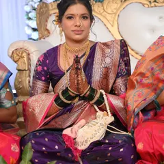 A beautiful bride ready for her Vidhi ceremony in a stunning purple Paithani saree. The makeup is soft and romantic, with a focus on her expressive eyes.