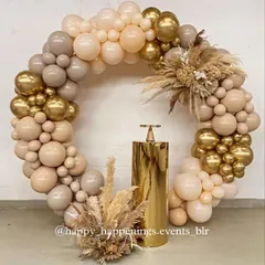 This circular balloon arrangement in nude and gold tones creates a stunning focal point for any event. The gold pedestal in the center is ideal for showcasing a cake, and the dried floral arrangements at the base complete the cohesive boho-chic theme.