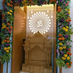 We decorated this beautiful home mandir with a full floral arch made of bright marigolds, purple statice, and baby's breath. The design complements the intricate wooden temple and the backlit 'Om' panel, creating a truly divine prayer space.