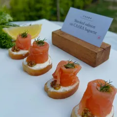 Smoked salmon elegantly rolled and served on a slice of our freshly baked baguette. This classic canapé is finished with dill and a touch of mustard, offering a sophisticated and timeless flavor.