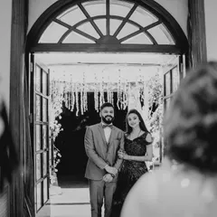 A candid black and white shot of the couple's grand entrance, seen from the perspective of their guests.