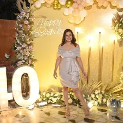 The birthday girl looking radiant at her glamorous 40th party. The warm lighting and gold accents create a festive and celebratory atmosphere.