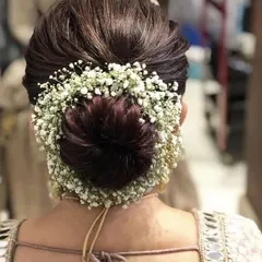 For those special occasions, I love creating hairstyles that are both messy and formal. This beautiful bun, adorned with delicate baby's breath flowers, is a timeless choice for weddings and festive events, offering an elegant yet modern look.