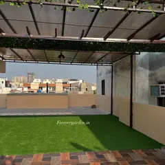 Another angle of the same terrace project. The artificial turf is laid over the existing tile, seamlessly integrating with the wooden flooring to define the green space.