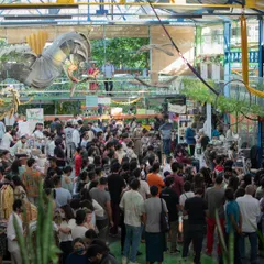 A wide-angle view from above showing our Central Arena packed with a large, engaged crowd during a bustling market event. This demonstrates the scale and vibrant atmosphere our venue can accommodate.
