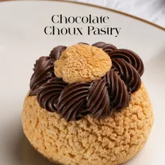 Our Chocolate Choux Pastry, featuring a crisp craquelin shell filled with a decadent chocolate cream. It's a perfect bite of texture and rich flavour, a must-try for any pastry lover.