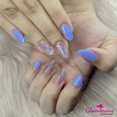 A cool and modern look. This design features a solid periwinkle blue polish on most nails, with accent nails showcasing a sheer base and abstract purple and silver swirls.