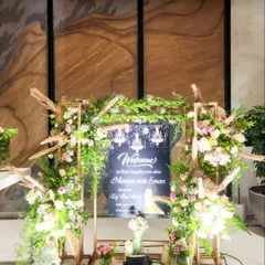 This rustic-chic welcome sign is framed with a mix of pampas grass, fresh greenery, and pastel flowers, creating a warm and inviting entrance.