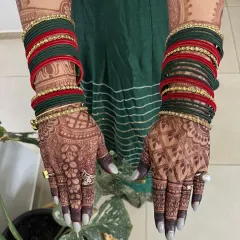 The beautiful, dark stain from a Karwa Chauth mehendi, pictured here with traditional bangles. The color is deep and even, highlighting every intricate detail.