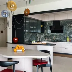 A glimpse into a residential project where the goal was to be bold, eccentric, and fun. This open-plan kitchen and dining area uses a dramatic marble backsplash, fluted glass, and a custom-designed, free-flowing dining island to create a space that is as impactful as a piece of art.