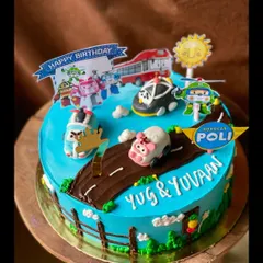 A Robocar Poli themed cake for a young fan. The design includes a road, grass, and various character toppers to create a playful scene.