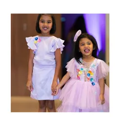 A closer look at our coordinated lilac sister sets. The younger sister's dress is full of tulle and embellishments, while the older sister's is a more understated but equally beautiful matching design.