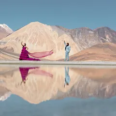 The serene beauty of Leh, where the mountains meet their perfect reflection. This shot captures a quiet, epic moment, with the vibrant purple gown creating a stunning contrast against the tranquil blues and earthy tones of Pangong Lake.