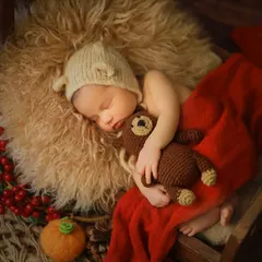A perfectly cozy and sleepy newborn, nestled with a tiny teddy bear. We use soft textures, warm tones, and simple props to create a safe and adorable setting, highlighting the baby's peacefulness during these first few weeks.
