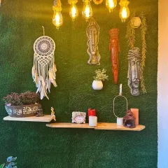 A closer look at the details on our "Green Carpet" balcony. The wall is covered in high quality artificial grass and decorated with rope lighting, tribal masks, and a dreamcatcher for a bohemian vibe.