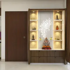 A floor-to-ceiling pooja unit designed to maximize vertical space. The design features a backlit panel with a delicate peacock feather motif, with display shelves on either side illuminated by spotlights. The combination of dark wood and a white marble base provides a balanced, contemporary look.