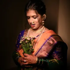 A beautiful, softly lit portrait of the bride holding a bouquet, looking down with a gentle smile.
