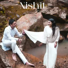 A serene portrait by the rocks, with the couple dressed in white. This image has a pure and almost spiritual quality, reflecting the calm and gentle nature of their love story.