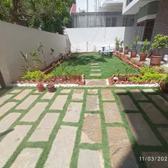 A complete residential backyard makeover we recently completed in Bangalore. The project included installing a new lawn, creating a stone paver patio with artificial grass inserts, and lining the space with neat garden beds and potted plants.