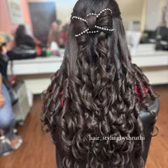 A half-up hairstyle where the bow itself is sculpted from hair and studded with pearls. This intricate detail elevates the style from simple to stunning.
