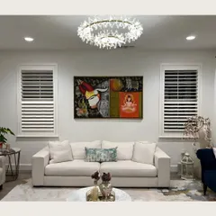 A vibrant mythological painting featuring Nandi and Lord Shiva becomes a powerful statement piece in this modern living room, beautifully centered between two windows.