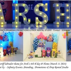 A unique Sheriff Labrador theme for a fourth birthday at home. The setup includes character cutouts, a blue and red balloon garland, and large marquee letters spelling out the birthday boy's name.