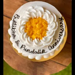 An anniversary cake in my seasonal mango flavor, decorated with fresh mango chunks in the center.