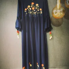 A contemporary take on the classic long dress in a deep navy blue. This piece features beautiful floral embroidery on the yoke and hem, with tassel details on the sleeves for a playful touch.