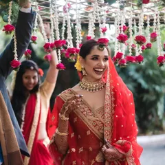A radiant bride makes her entrance under a 'phoolon ki chadar', a floral canopy of red roses. I work to make every moment, big or small, feel special and picture-perfect.