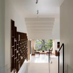 A full view of the multi-level home, featuring the custom recessed bookcase that climbs the wall. I designed this piece to be a central spine for the house, connecting the floors and providing a home for the family's book collection.