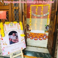 The entrance to an Annaprashan ceremony sets a tone of love and tradition. Here, a personalized welcome sign for baby Samarth, adorned with marigold garlands, greets guests as they arrive to witness his first meal.